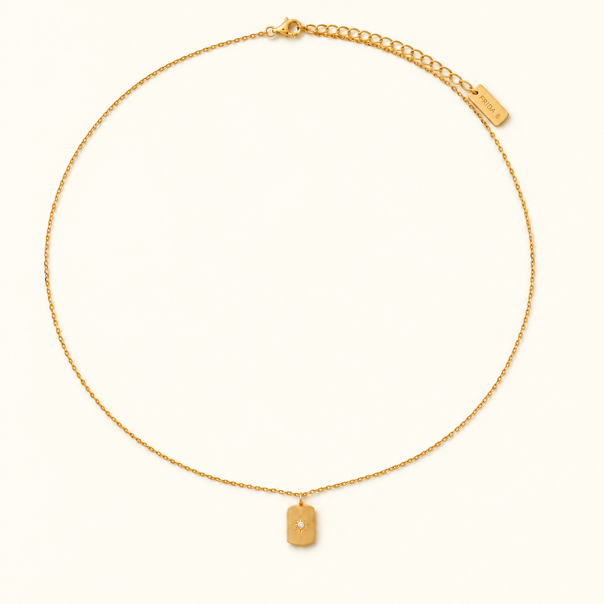 Stella Pendant Necklace in gold, full length with lobster clasp and extender chain, on ivory.