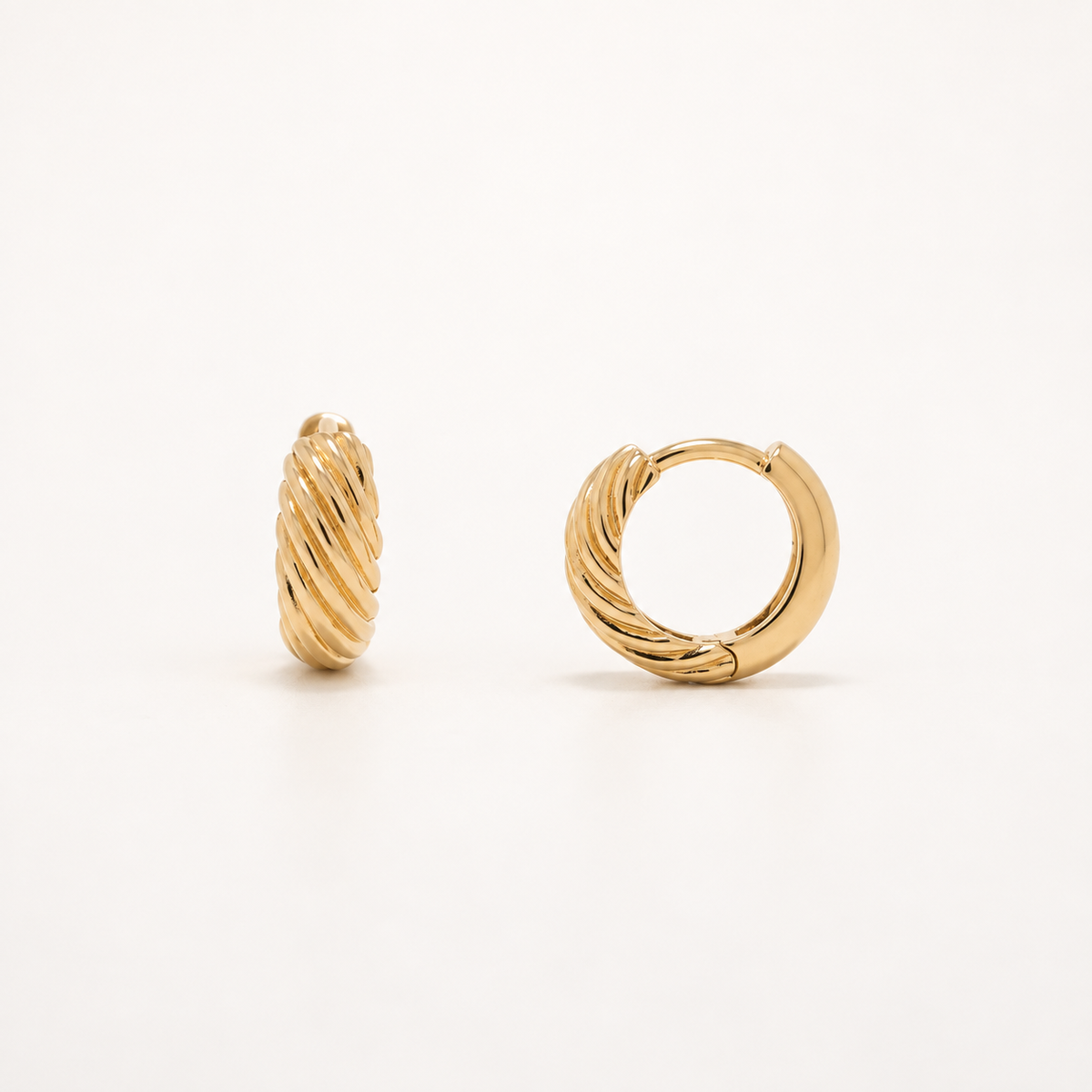 A pair of gold huggie hoop earrings with a twisted rope texture, displayed on a clean white background.