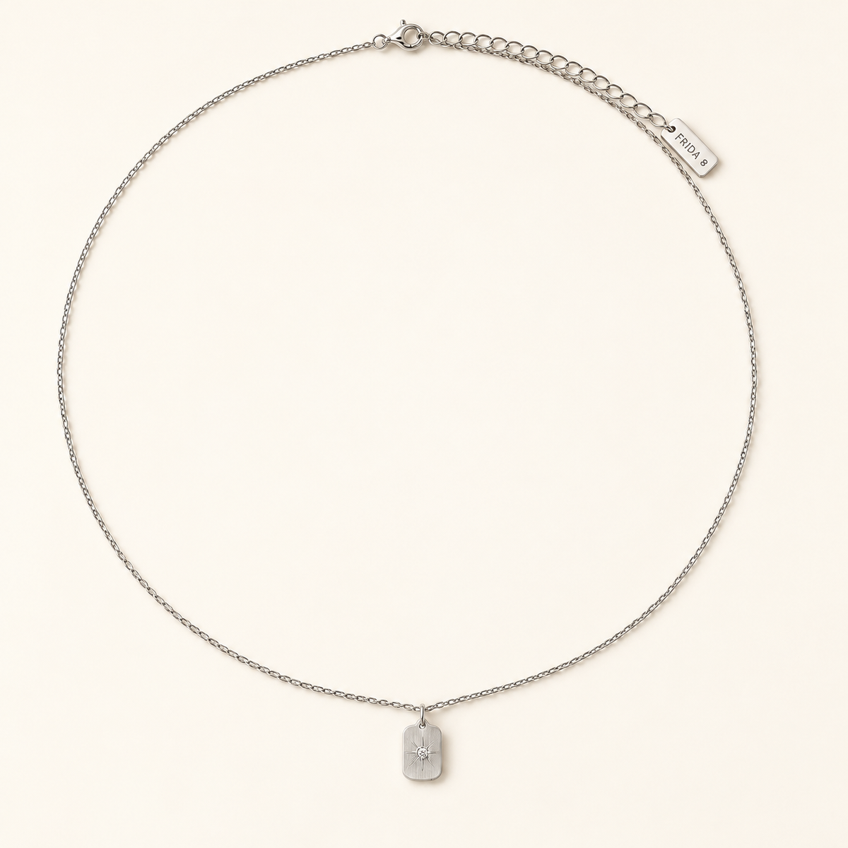 Stella Pendant Necklace in silver, full length with lobster clasp and extender chain, on ivory.